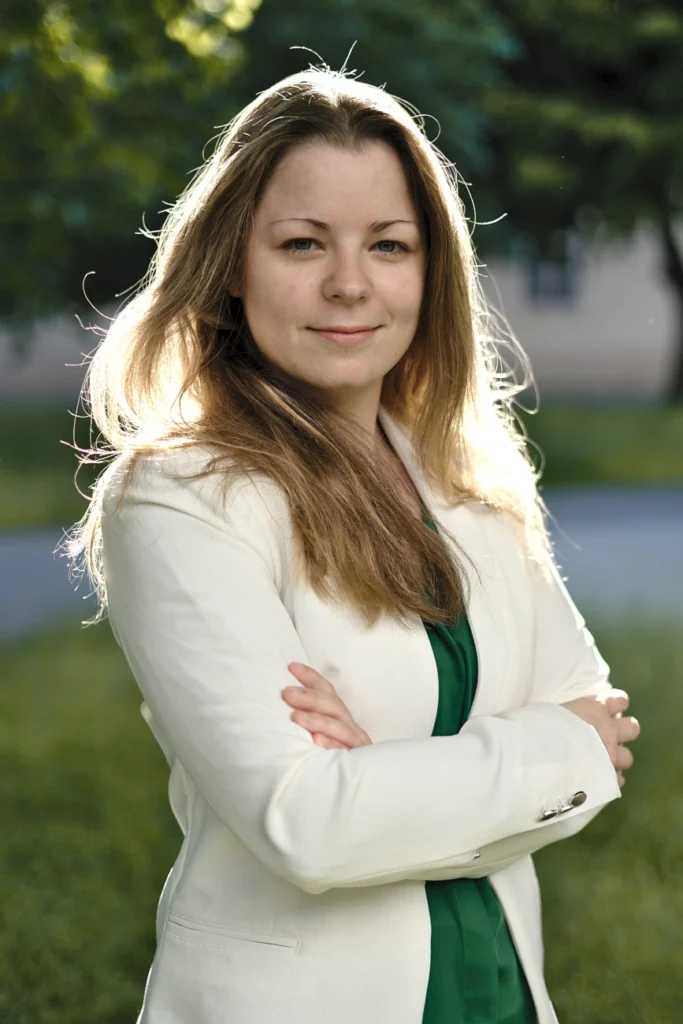 Junge Frau mit langen Haaren, Blazer und grüner Bluse